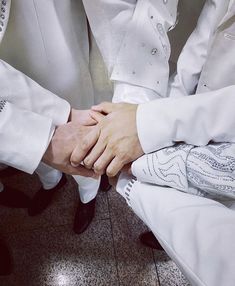 two people holding hands while sitting down