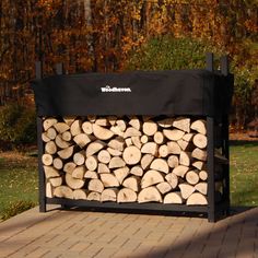 a pile of logs sitting on top of a wooden bench in front of some trees