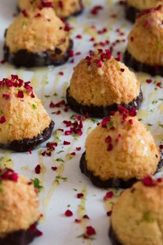 small desserts are arranged on a white plate with confetti sprinkles