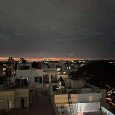 the night sky is dark and cloudy over some buildings