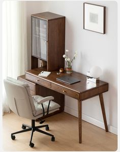 an office desk with a laptop computer on it and a chair in front of it