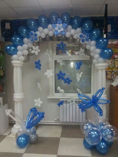 balloon arch with blue and white balloons in the shape of flowers, butterflies and snowflakes