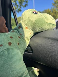 a stuffed animal sitting in the drivers seat of a car