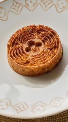 a piece of bread that is on a white plate with gold designs around the edges