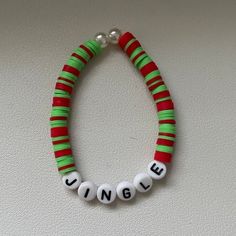 a beaded bracelet with the word unique written in white and green letters on it