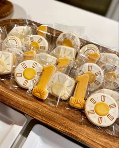 some cookies that are sitting on a wooden board with plastic wrappers around them and clock decorations in the middle