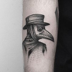 a black and white photo of a man's arm with a bird wearing a top hat