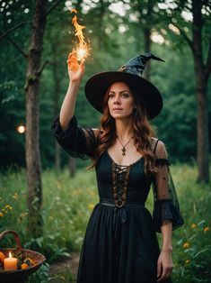 a woman dressed as a witch holding a lit candle in her hand