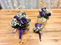 three small bouquets of purple roses and baby's breath are sitting on a table