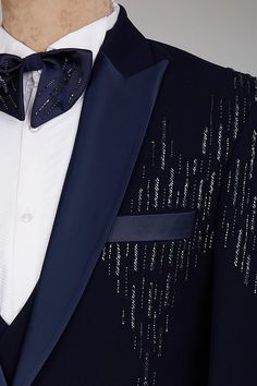 a man wearing a blue tuxedo with silver sequins on the lapel