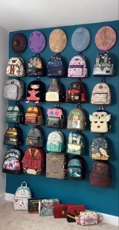 a blue wall filled with lots of backpacks and purses on it's sides