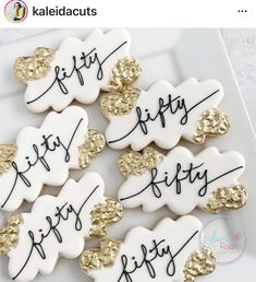 decorated cookies with gold and white frosting are on a plate that says happy 50th