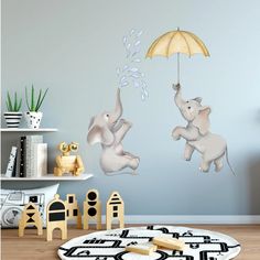 two elephants are jumping in the air with an umbrella