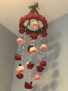 a wind chime with roses and pearls hanging from the ceiling