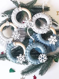 some ornaments are hanging from a christmas tree with snowflakes on the top and below them