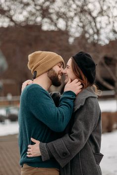 a man and woman standing close to each other in the snow