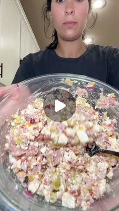 a woman holding a large bowl filled with food