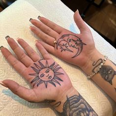 two hands with tattoos on them sitting next to each other