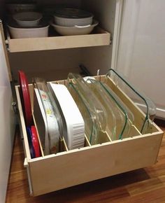 an open drawer in a kitchen filled with dishes