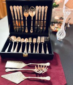 an assortment of silverware in a black case