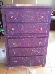 a purple dresser sitting on top of a tiled floor