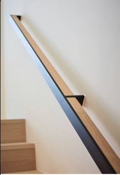 a wooden stair case with black metal handrails