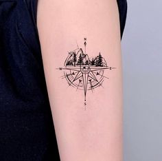 a woman's arm with a compass tattoo on the left side of her body