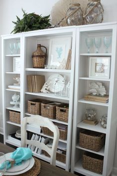 a white bookcase filled with lots of books and wicker baskets on top of it