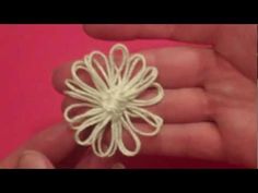 a person is holding a small white object in their hand and it looks like a flower