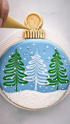 a cookie decorated like a christmas ornament with trees on it