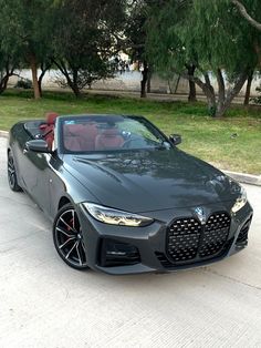 the bmw z4 roadster convertible is parked in front of some trees