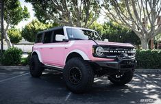 a pink truck parked in a parking lot