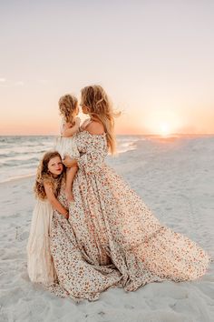 mother and two daughters on the beach at sunset