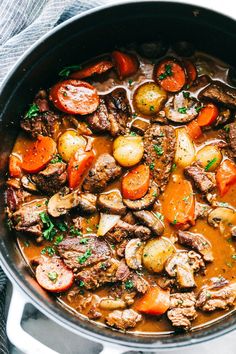 beef stew with carrots, potatoes and parsley in a pot