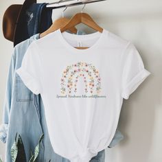 Spread kindness wherever you go with this beautiful floral rainbow tee. Featuring a stunning pressed flower design, this t-shirt is perfect for spreading positivity and joy. Made from high-quality materials, it's comfortable and durable, making it the perfect addition to any wardrobe. This classic unisex jersey short sleeve tee fits like a well-loved favorite. Soft cotton and quality print make users fall in love with it over and over again. These t-shirts have-ribbed knit collars to bolster shaping. The shoulders have taping for better fit over time. Dual side seams hold the garment's shape for longer.  .: 100% Airlume combed and ringspun cotton (fiber content may vary for different colors) .: Light fabric (4.2 oz/yd² (142 g/m .: Retail fit .: Tear away label .: Runs true to size For more Spring Graphic Tee With Rainbow Print, Spring Rainbow Graphic Print Tops, Spring Rainbow Short Sleeve T-shirt, Social Worker Outfits, Flowers Rainbow, Floral Rainbow, Kindness Shirt, Spreading Positivity, Rainbow Tee