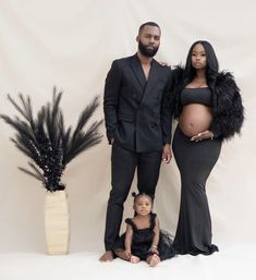 a man and woman standing next to a baby