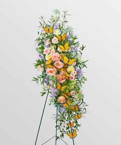 a floral display with butterflies and flowers on it's sides, in front of a white background