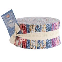 a roll of multicolored fabric with a tag on it's end and a ribbon