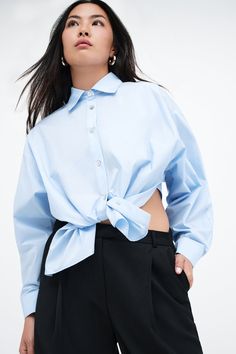 Our Ezra Shirt is a capsule wardrobe dream for your closet. Crafted from 100% crisp European poplin cotton, she offers a classic button-up silhouette in front, but with a cropped back for modern edge. Say hello, as well, to her diagonal seams at the front, sleek collar and long dolman sleeves finished with mother-of-pearl button cuffs. Wear Ezra tucked, tied or open and free—she never fails to inspire new looks.[SPLIT] Shannon, in light blue, is 5'8" (173 cm) tall, wearing a size M. Rocio, in li Dolman Sleeve Shirt, Tunic Hoodie, Cotton Poplin Shirt, New Looks, Poplin Shirt, Mother Of Pearl Buttons, Dolman Sleeve, Shirt Outfit, Capsule Wardrobe