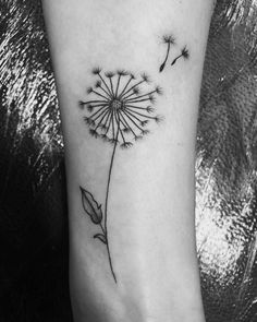 a black and white photo of a dandelion tattoo