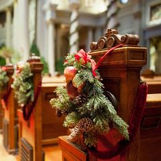 a row of wooden pews with christmas decorations on the top and bottom, along with pine cones