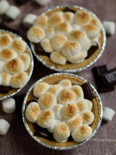 three small pies with marshmallows in them on top of a table