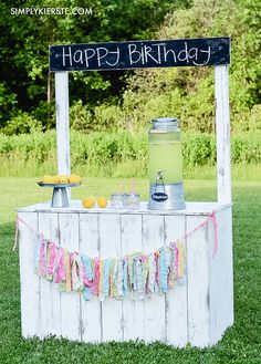 a happy birthday sign on top of a table with lemons and water in it