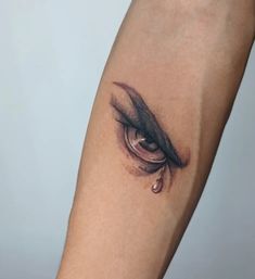 a woman's arm with a teary eye tattoo on the left side of her leg