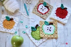 crocheted apples and pears are sitting on the table next to yarn, scissors and an apple