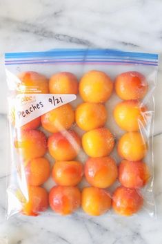 a bag filled with oranges sitting on top of a marble counter