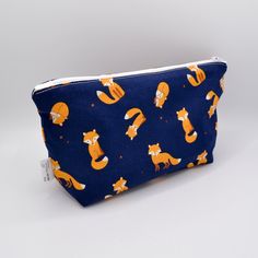 Navy Foxes Makeup Bag/ Eco Cosmetics Bag/ Pencil Case/ Wash Bag/ Toiletries Bag/ Reusable Pad Bag / Accessory Bag/ Mother's Day Gift This Navy Foxes Makeup bag is super stylish! With a boxed bottom, you can fit so much more in it! It is made of 100% cotton print fabric and a cotton calico lining, which is raw, undyed cotton.  We can also do custom orders, so if you have something else in mind, please don't hesitate to contact us.  Measurements: - Approx. 22cm x 15cm We can make custom orders, so if this is of interest to you, don't hesitate to send us a message. Thank you for supporting a Small Business! All of our packaging is 100% recyclable. Please try to reuse or recycle this packaging and try to reduce waste. Rectangular Reusable Bag For Personal Use, Everyday Pouch Cosmetic Bag, Reusable Pouch Bags, Orange Zipper Pouch Bag For Gift, Fox Makeup, Reusable Pad, Pad Bag, Toiletry Storage, Wash Bags