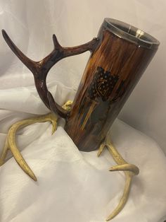 two deer antlers sitting next to each other on a white cloth covered tablecloth