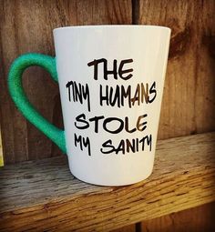 a coffee cup with writing on it that says the tiny humans stole my saniti