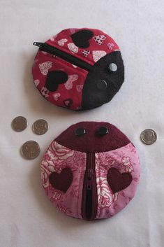 two coin purses sitting next to each other on a white surface with coins scattered around them